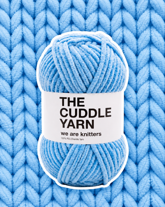 The Cuddle Yarn Blue skein on matching knit background